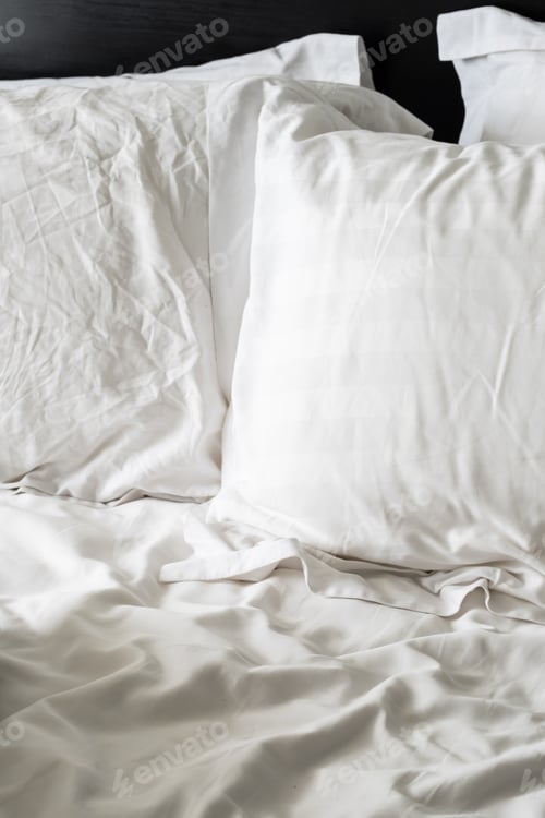 Preview: Empty wrinkled white bedding, close up.