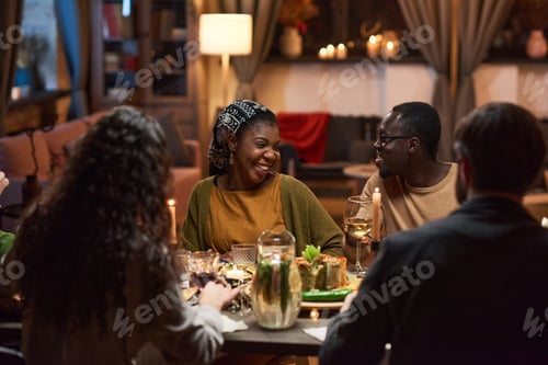 Preview: Happy friends sitting at dining table
