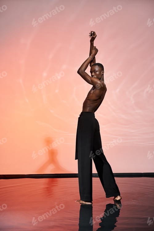 Preview: charming shirtless african american man standing and looking at camera surrounded by red lights