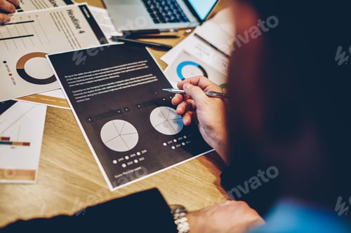 Preview: Faceless entrepreneur browsing report in office