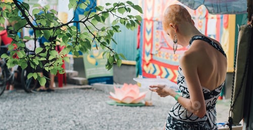 Preview: Woman in Outdoor Market Looking at Object
