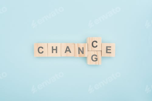 Preview: top view switching chance to change lettering made of wooden blocks on blue background