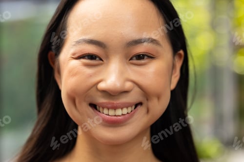 Preview: Smiling asian woman with long hair, close-up portrait outdoors in natural light