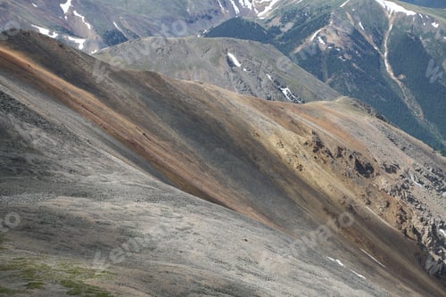 Preview: Scenic mountain terrain with snow patches.
