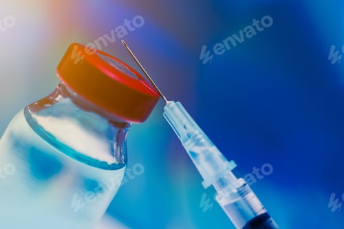 Preview: Syringe leaning up against vial, vaccine concept