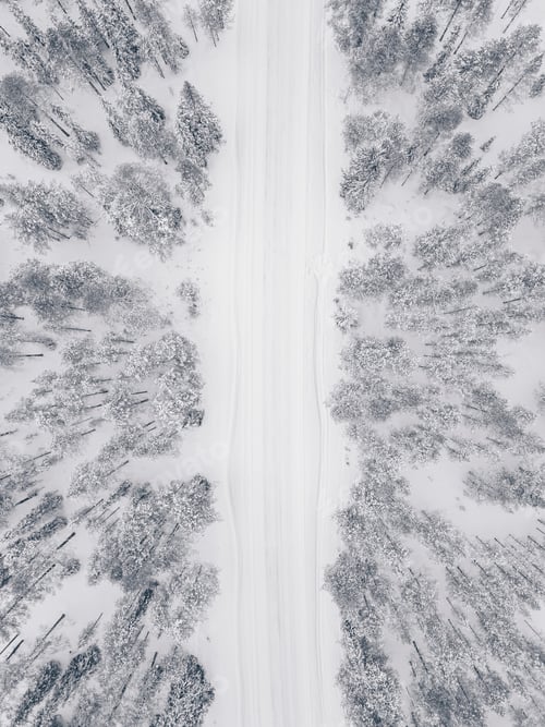 Preview: Aerial drone view of winter forest and road covered with snow.