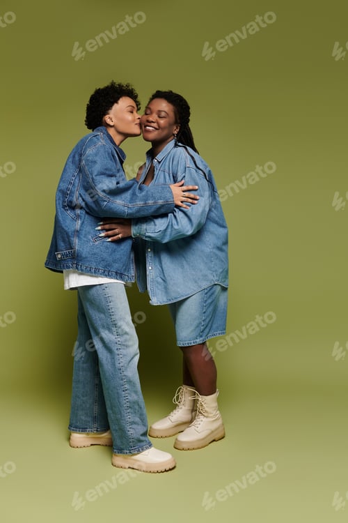 Preview: Couple showcases love in stylish denim outfits against vibrant green backdrop