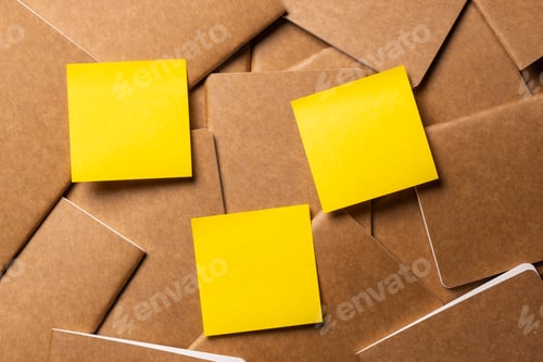 Preview: yellow sticky note on kraft brown notebook on table