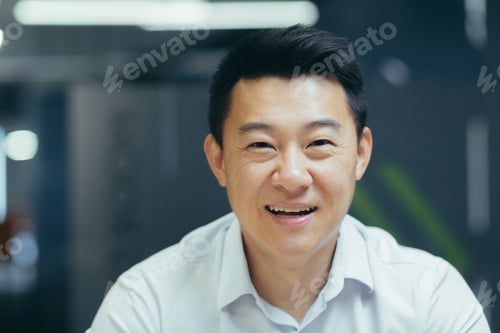 Preview: Close-up photo of a young Asian businessman, accountant, manager in the office smiling at the