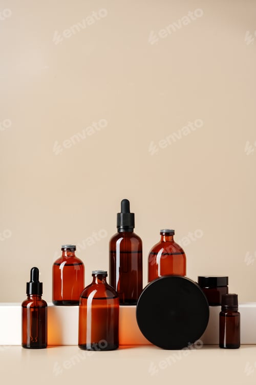 Preview: Set of brown glass bottles with essential oils on stand on beige background