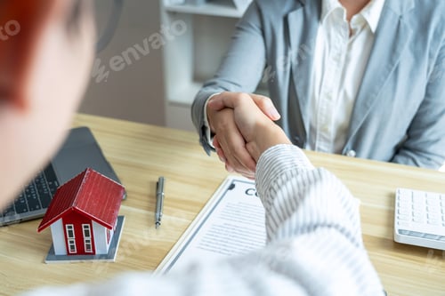 Preview: Estate agent and customers shaking hands together celebrating finished contract after signing