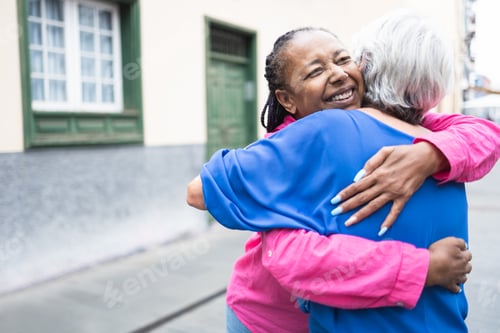 Preview: Two Smiling Women Embracing in the City Street