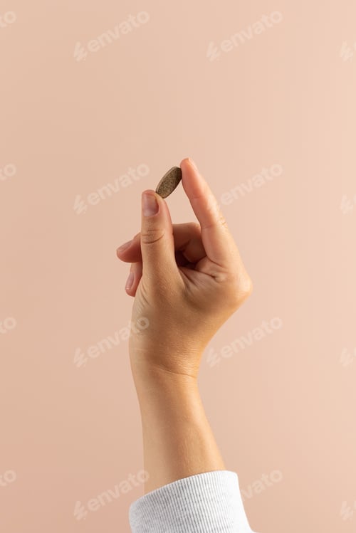 Preview: A woman's hand holds a pill with a medicinal supplement . Healthcare, food additives and medicines.
