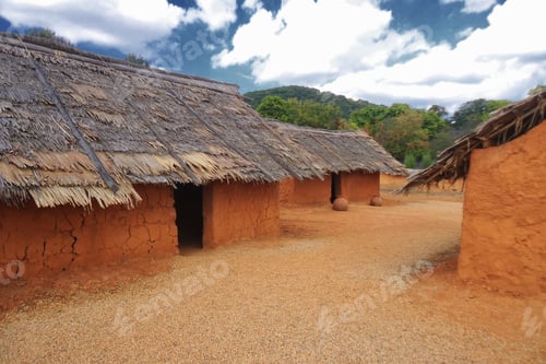 Preview: Orange clay huts with thatched roofs of west African village, exhibit recreation