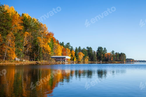 Preview: Typical Minnesota lake shoreline with dock and boat during autumn
