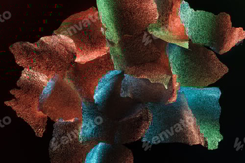 Preview: abstract background of textured foil pieces with colorful illumination isolated on black