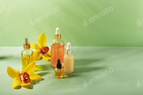 Preview: Cosmetic care products in glass bottles with orchid flowers - serums, cream, gel, oils. Concept for