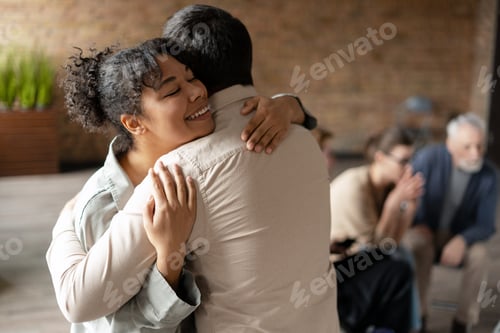 Preview: Happy african american woman hugging coach at therapy session