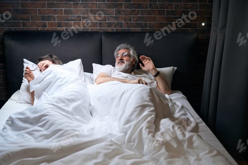 Preview: Old couple talking before sleep in hotel