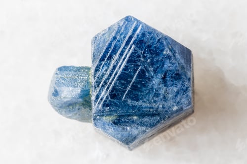 Preview: unpolished blue sapphire crystal on white marble