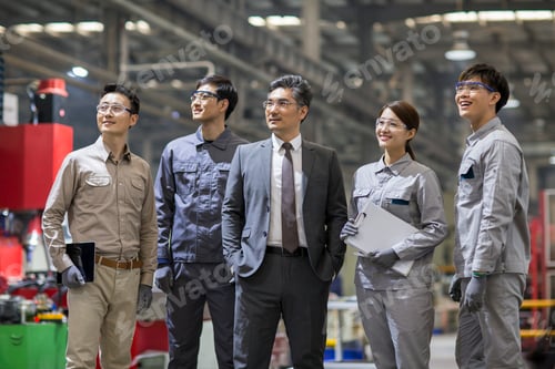 Preview: Confident businessman and engineering team in the factory