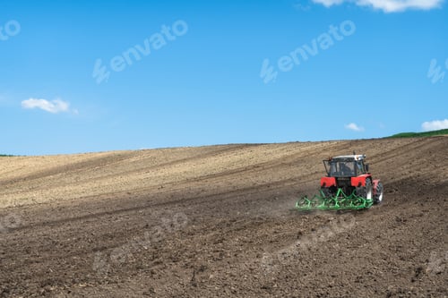 Preview: Tractor working in farm fields, rural landscape