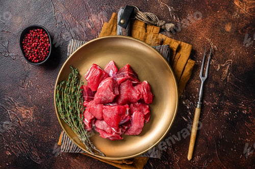 Preview: Raw diced lamb mutton meat with thyme. Dark background. Top view