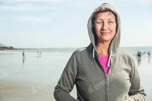 Preview: Woman on beach in hooded top, Folkestone, UK