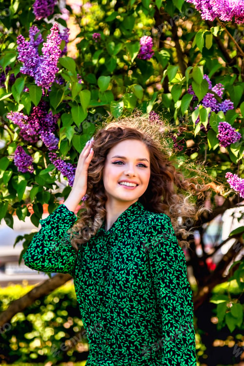 Preview: Portrait of gorgeous french lady in green dress, enjoying near lilac flowers, smile looking