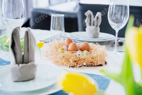 Preview: Beautiful Easter table setting with festive decor indoors,colorful eggs