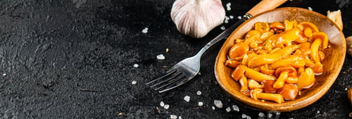 Preview: Marinated mushrooms on a plate with garlic and salt.