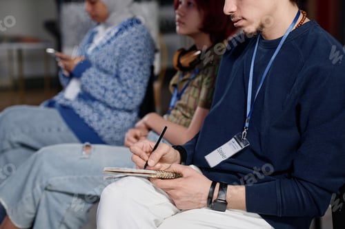 Preview: Young Man Writing Notes During Conference