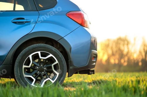 Preview: Close up of blue off road car on green grass. Traveling by auto, adventure in wildlife, expedition