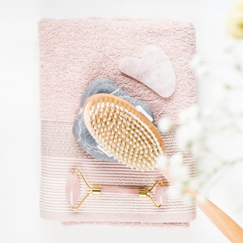 Preview: Massage brush, stone, face roller on pink towel