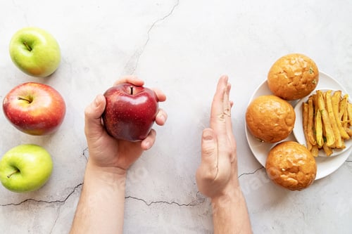 Preview: Healthy and unhealthy food concept. Apples vs french fries and burgers top view flat lay