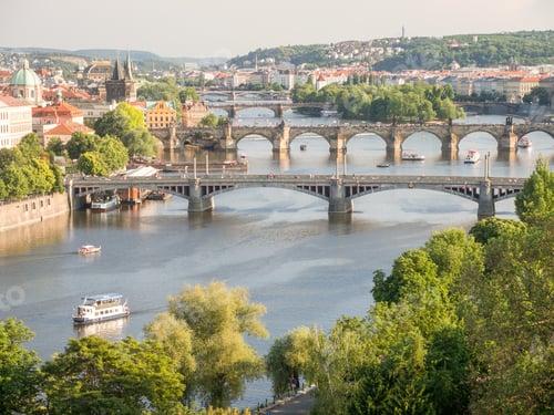 Preview: Landscape of the Vltava River with bridges over it surrounded by greenery and buildings in Prague