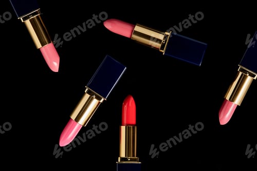 Preview: top view of various shades of lipsticks in tubes isolated on black