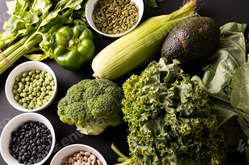 Preview: Directly above shot of various green vegetables, fruit, herb with seeds and legumes on table