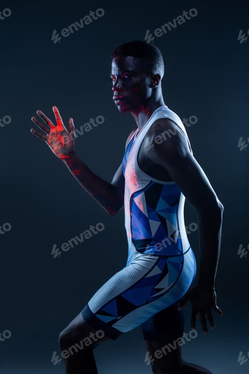 Preview: Muscular male runner in studio with neon light