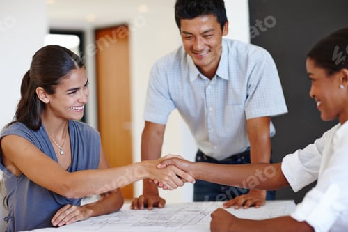 Preview: Shot of two businesswomen shaking hands with a male colleague watching