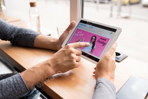 Visualização: Jovem segurando o touchpad e apontando para o protetor de tela da venda da Black Friday