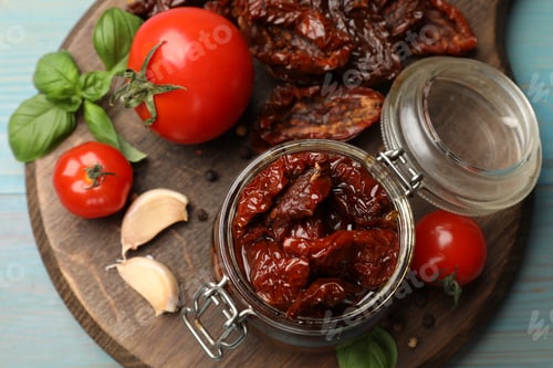 Preview: Tasty sun dried tomatoes, fresh vegetables and peppercorns on light blue wooden table, top view