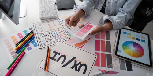 Preview: Stylish woman Ux designer using digital tablet and computer planning new website wireframe at