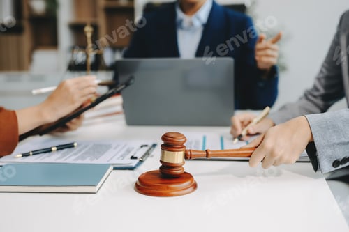 Preview: business people and lawyers discussing contract papers sitting at the table.