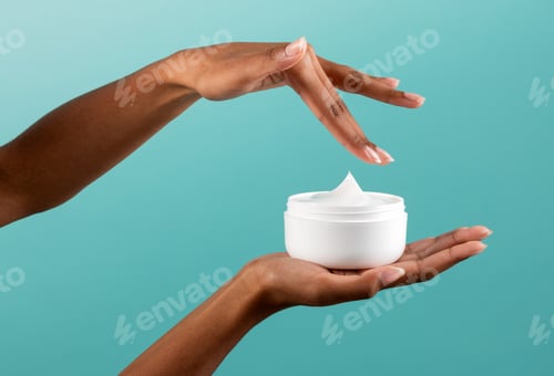 Preview: Anonymous black woman taking cream from jar