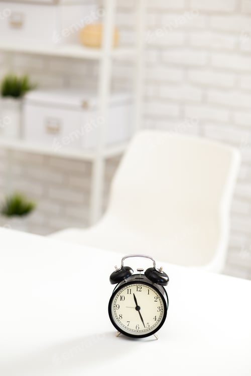 Preview: Clock placed on a table in a minimalistic workspace with a white chair and organized shelves