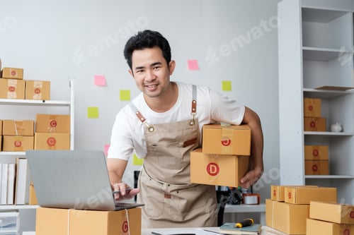 Preview: Asian man checking order and customer's details and addresses on laptop or box in order to prepare