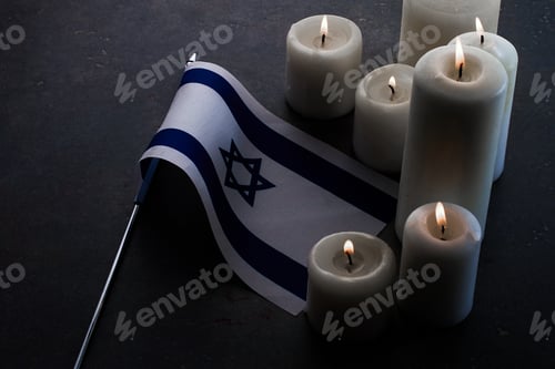 Preview: Burning candles and flag of Israel on dark background. Holocaust remembrance day