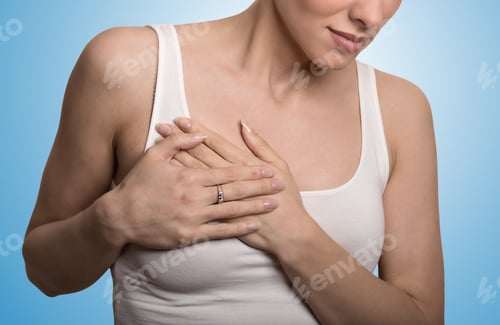 Preview: Closeup Cropped Portrait Young Woman With Breast Pain Touching Chest Colored Isolated On Blue