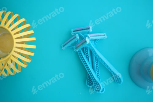 Preview: Bright blue razors arranged on a turquoise background